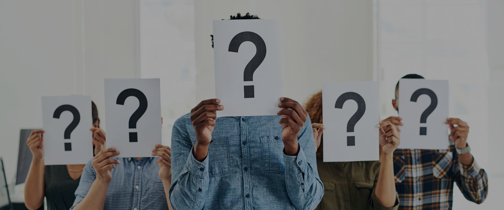 People holding question mark signs.